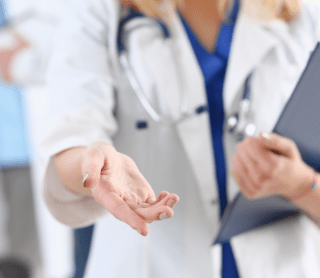 Médica com a mão esticada para a frente