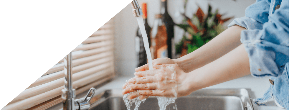 Mulher a lavar as mãos na cozinha