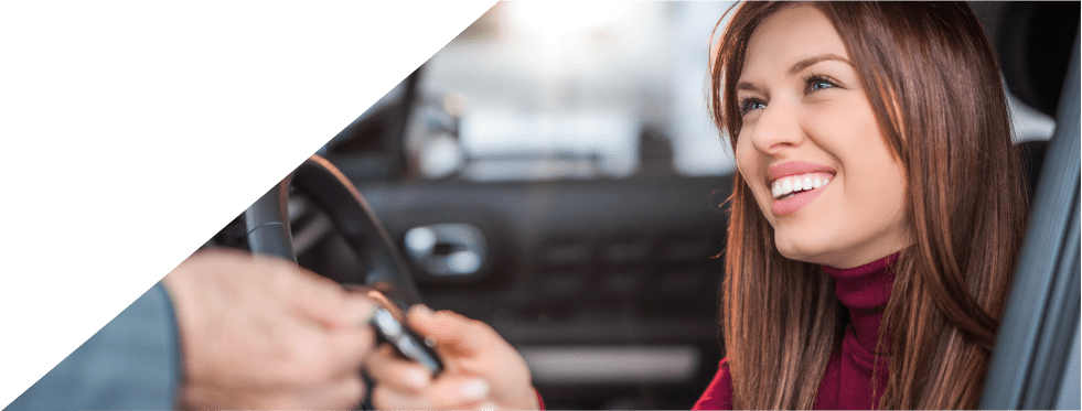 Mulher feliz no seu carro com a chave na mão