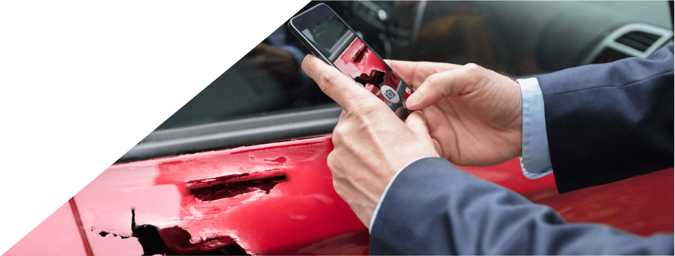 Homem a tirar fotografia ao seu carro partido