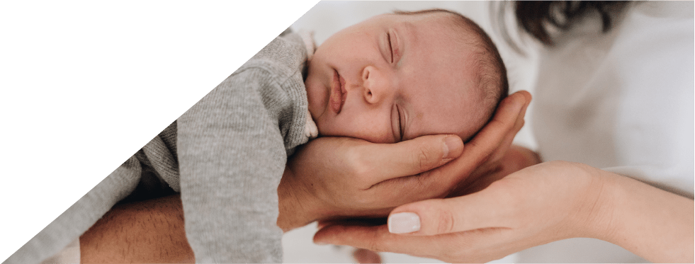 bebé a dormir nas mãos dos pais
