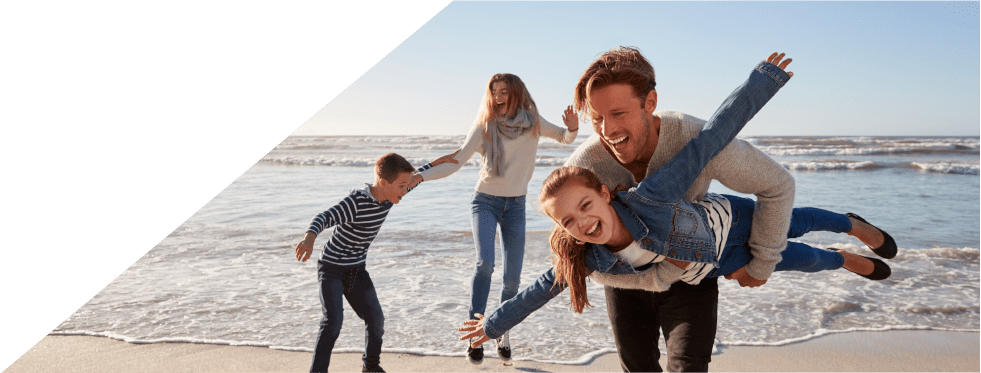 Família de pais e filhos a brincar na praia