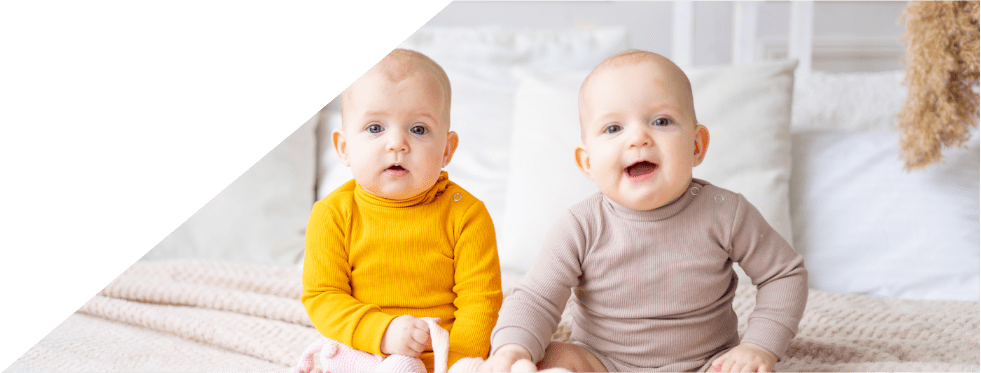 dois bebés sentados na cama
