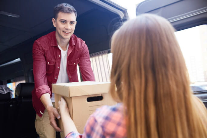 Homem que vai emigrar a segurar uma caixa de cartão