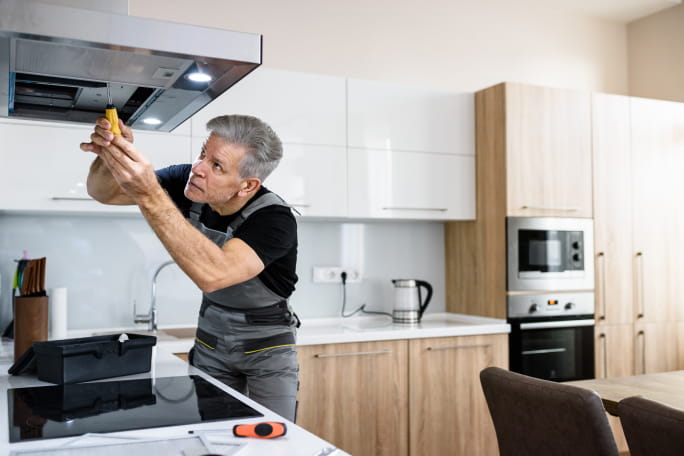 Homem a arranjar um exaustor.