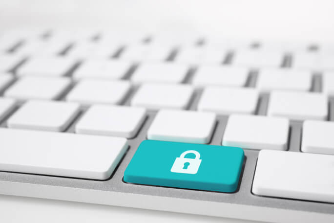 Teclado branco de computador com uma tecla azul com a imagem de um cadeado