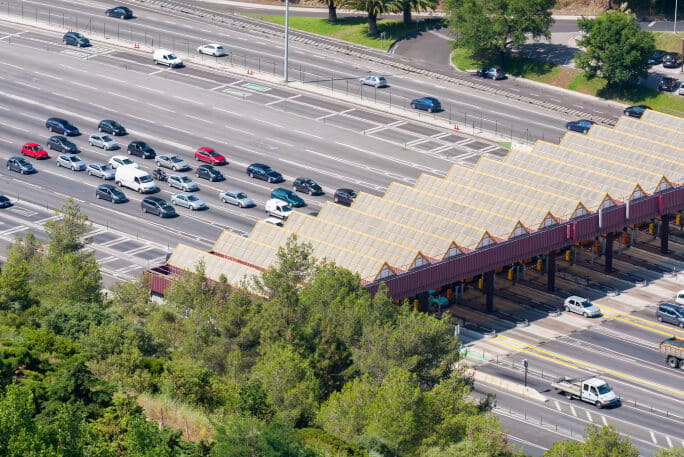 Carros a passar por uma portagem eletrónica.