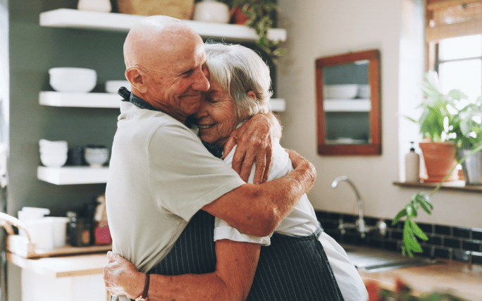 Um homem e uma mulher de idade abraçados