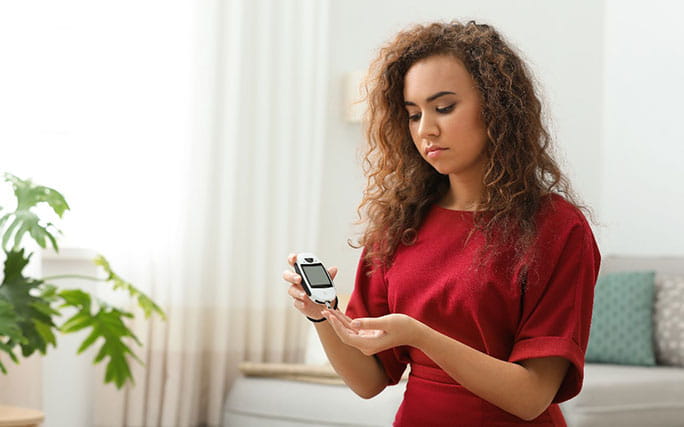 Mulher com diabetes a medir os seus níveis de glicose