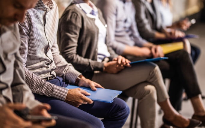 Pessoas sentadas à espera para o atendimento relativo ao subsídio de desemprego.