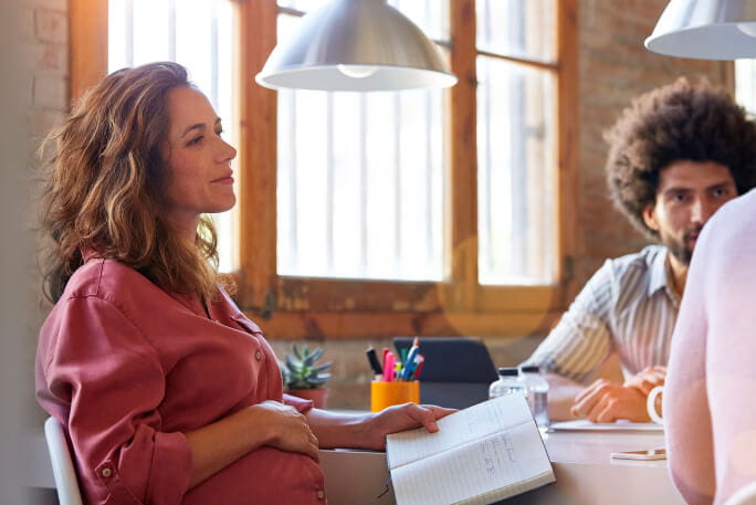 Jovem mulher grávida num ambiente de trabalho 