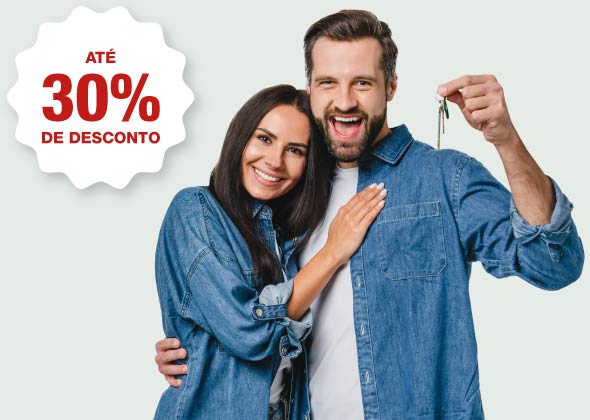 Homem e Mulher abraçados com chave de casa na mão