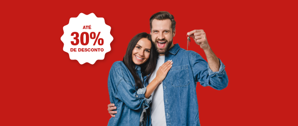 Homem e Mulher abraçados com chave de casa na mão