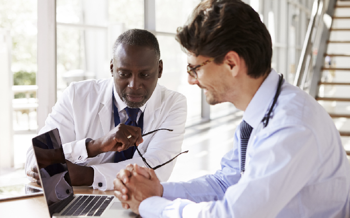 dois médicos a olhar para o computador 6-comportamentos-que-ajudam-a-prevenir-o-cancro-2